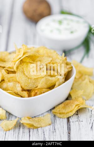 Chips (saure Sahne Geschmack) auf rustikalen Holzmöbeln Hintergrund (Nahaufnahme) Stockfoto