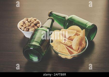 Bier in Flaschen mit Snack auf Holz- Hintergrund Stockfoto