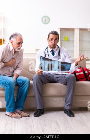 Die jungen männlichen Arzt Besuch alten Patienten zu Hause Stockfoto