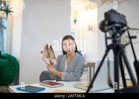 Junge brünette Frau präsentiert sehr schöne Schuhe Stockfoto