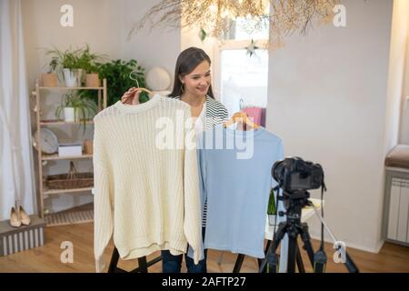 Gut aussehende junge Frau die Beratung über Kleidung Stockfoto