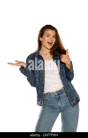 Junge schöne Frau in Jeans Holding imaginäre Objekt auf ihre Hand auf weißem Hintergrund Stockfoto