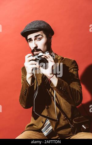 Sehr positive Fotograf im Studio mit Kamera posieren Stockfoto