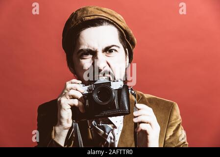 Sehr positive Fotograf im Studio mit Kamera posieren Stockfoto