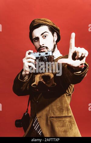 Sehr positive Fotograf im Studio mit Kamera posieren Stockfoto