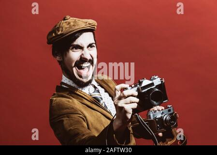 Sehr positive Fotograf im Studio mit Kamera posieren Stockfoto