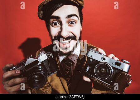 Sehr positive Fotograf im Studio mit Kamera posieren Stockfoto