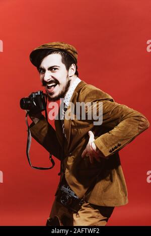 Sehr positive Fotograf im Studio mit Kamera posieren Stockfoto
