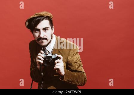 Sehr positive Fotograf im Studio mit Kamera posieren Stockfoto