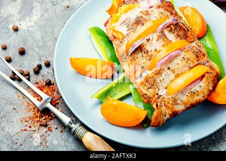 Gebratene Schweinelende mit gebackenen Persimmon. Schweinebraten und Persimmon auf Platte Stockfoto