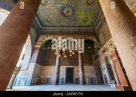 Reich verzierte Decke mit blauen und goldenen Blumen muster Dekorationen von zwei Spalten im Sultan Barquq Moschee gerahmt, Al Moez Straße, alte Kairo, Ägypten Stockfoto