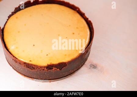 Ganz, frisch gebackene Käsetorte auf neutralem Hintergrund Stockfoto