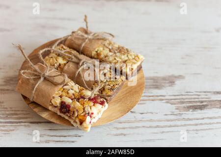 Müsli Müsliriegel mit Nüssen, Obst und Beeren auf hölzernen Tisch Hintergrund. Gesunde süße hausgemachte Desserts Snacks. Stockfoto