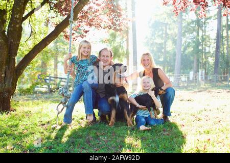 Portrait glückliche Familie mit Hunden im sonnigen Herbst Park Stockfoto