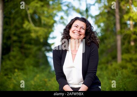 Portrait zuversichtlich, glückliche Frau in Wäldern lächeln Stockfoto