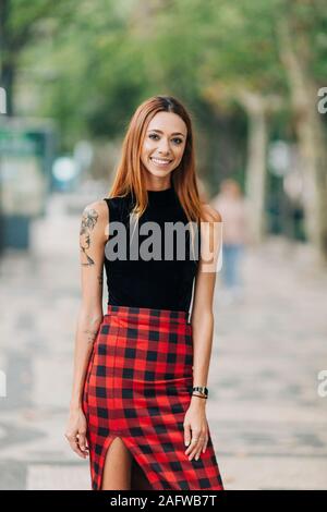 Portrait zuversichtlich, stilvolle junge Frau eingecheckt Rock Stockfoto