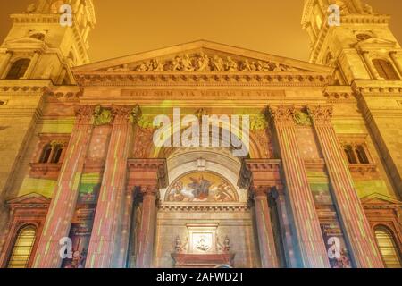 Budapest, Ungarn Weihnachtsmarkt am St Stephen Square mit animierten zeigen. Nachtansicht des Advents fest mit Laser visual auf Basilika Fassade projiziert. Stockfoto