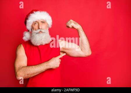 Portrait von zuversichtlich Santa Claus in Gap hat seine Trizeps Fitness Training das Tragen modischer Sportbekleidung über den roten Hintergrund isoliert Stockfoto