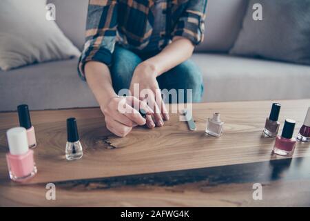 7/8-closeup Foto von Lady gemacht Korrektur Fingernägel, die Polnischen Decklack, die Hand auf den Tisch tragen Freizeitkleidung sitzt ein gemütliches Sofa Stockfoto
