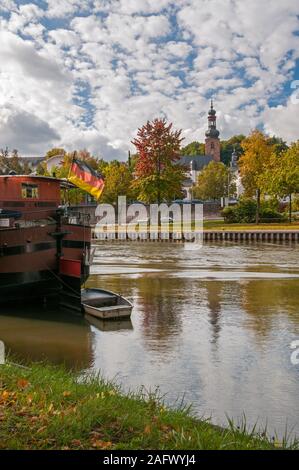 Boote an der Saar mit einer deutschen Flagge und die Schlosskirche im Hintergrund, Saarbrücken, Saarland, Deutschland Stockfoto