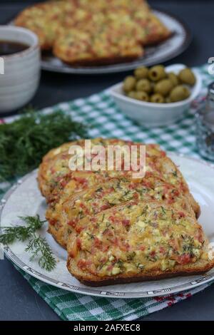 Hausgemachte Sandwiches mit Käse und Wurst vor dem Backen auf Pergament auf ein Backblech, das Kochen, vertikale Ausrichtung Stockfoto