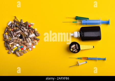 Pillen und Kapseln, die im Kreis. Set aus bunten Tabletten auf gelbem Hintergrund, kopieren. Drogen gesetzt gegenüber Sirup Flasche, Spritzen, Pipetten und Messlöffel. Medizin und Behandlung Konzept Stockfoto