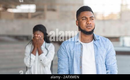Freund, Freundin nach draußen, deprimiert Frau weinen auf Hintergrund Streit Stockfoto