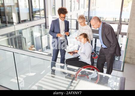 Im Rollstuhl Geschäftsfrau macht Termin Planung mit Kollegen während der Kaffeepause Stockfoto