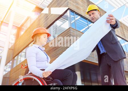 Frau im Rollstuhl hat die Bauleitung beim Bau Planung als Aufnahme Konzept Stockfoto