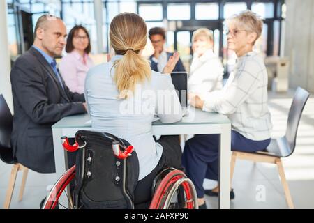 Business Frau in einem Rollstuhl in einem Projekt gemeinsam mit Kollegen Stockfoto