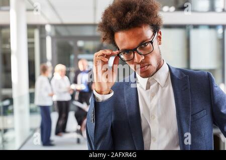 Cool African Business Start-up-Gründer im Büro mit Team im Hintergrund Stockfoto