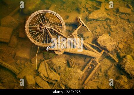 Fliegen - Trinkgeld: verlassene Fahrrad unter Wasser in einem Fluss Stockfoto