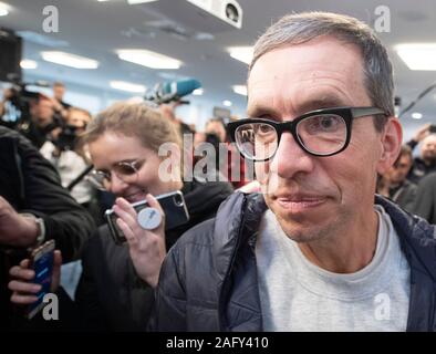 17 Dezember 2019, Hessen, Frankfurt/Main: Jens Söring wird von seinen Anhängern nach seiner Ankunft empfangen werden. Nach mehr als drei Jahrzehnten im Gefängnis, Sohn des Diplomaten kommt am Flughafen. Der 53-Jährige wurde in den USA von der Ermordung der Eltern seiner Freundin überführt und wurde erst vor wenigen Wochen begnadigt. Söring selbst hatte wiederholt bekräftigt seine Unschuld. Foto: Boris Roessler/dpa Stockfoto