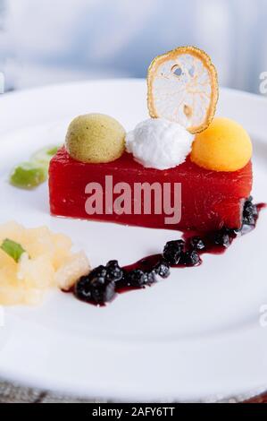 Kalte frische Wassermelone und gemischtes Obst Eis Sorbet auf der Oberseite mit süß-saurer Sauce Beeren in weißer Teller - Sommer gesund Dessert Stockfoto