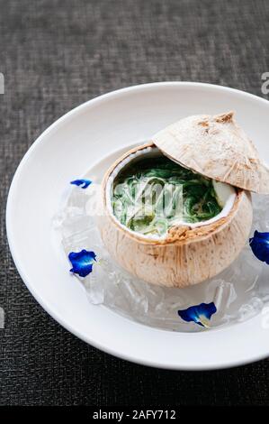 Lod Chong oder Cendol, Thailand und Südostasien Land traditionelle erfrischenden kalten Sweet Summer Dessert mit Kokosmilch in Coconut shell serviert. Stockfoto