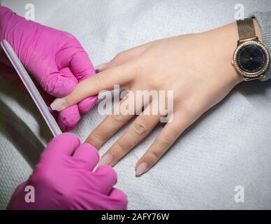 Frau, Nägel feilen durch eine professionelle Maniküre. Stockfoto