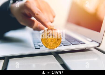 Geschäftsmann mit Bitcoin und Laptop Computer für Cryptocurrency ein neues virtuelles Geld und online Zahlung. Stockfoto