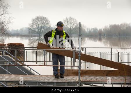 Worcester, Worcestershire, Großbritannien. 17 Dez, 2019. Worcester County Cricket Ground Überschwemmungen mit Wasser aus dem Haus und ist unter mehreren Füße von Wasser zum fünften Mal in 2019. Handwerker legen temporäre Spaziergang Boards den Zugang zu den Gebäuden des den Boden zu erleichtern. Credit: Peter Lopeman/Alamy leben Nachrichten Stockfoto