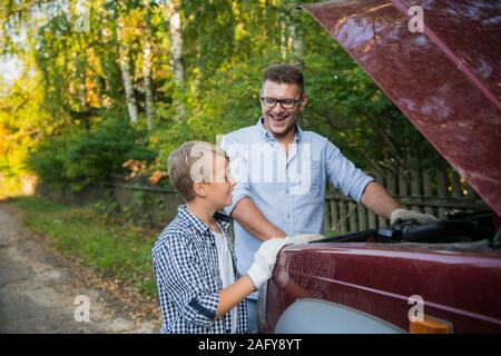 Vater Lehre, sein Sohn, wie das Öl auf der Familie Auto zu prüfen. Stockfoto