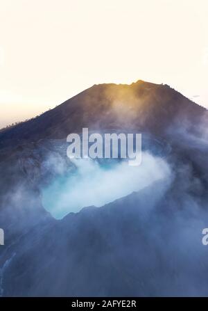 Atemberaubenden Sonnenaufgang über dem Ijen Vulkan mit dem Schönen türkisfarbenen sauren Crater Lake. Stockfoto