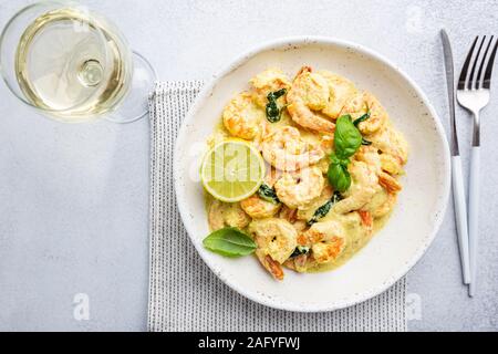 Garnelen in Sahnesauce mit Kokosmilch auf einem Teller, Ansicht von oben oder Ansicht von oben, flach Stockfoto