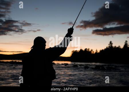 Eine Fliege Fischer fischen in den Abend auf einem See in Maine Stockfoto