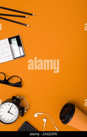 Schul- und Büromaterial liegen fein säuberlich auf einen orangen Hintergrund Stockfoto