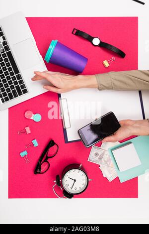 Schul- und Büromaterial liegen fein säuberlich auf einem rosa Hintergrund Stockfoto