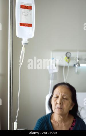 Südostasien alte Frau Infusion während der stationären Behandlung im Krankenhaus Stockfoto