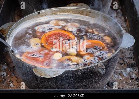 Warmen Wein, Glühwein, Getränke mit Rotwein mit verschiedenen Gewürzen verrühren, in großen kupfernen Topf in einem Weihnachten Lebensmittel Markt Glühwein Stockfoto