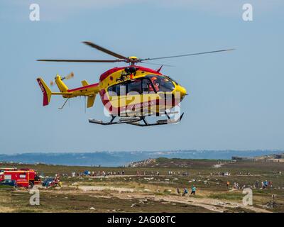 Katastrophenschutz Hubschrauber mit der Feuerwehr im Hintergrund. Frankreich. Stockfoto