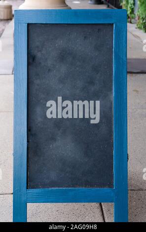 Leere gelöscht Schiefertafel mit blauen Holzmöbeln Grenze sitzt auf einem Bürgersteig Stockfoto