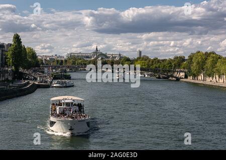 Überqueren Sie die Brücke in Paris mit Blick auf den Fluss und die vorbeifahrenden Boote Stockfoto