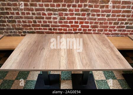Schönen rustikalen Holztisch gegen Red brick wall Stockfoto